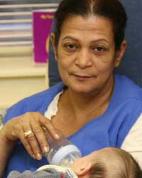 Day care center worker feeding a baby