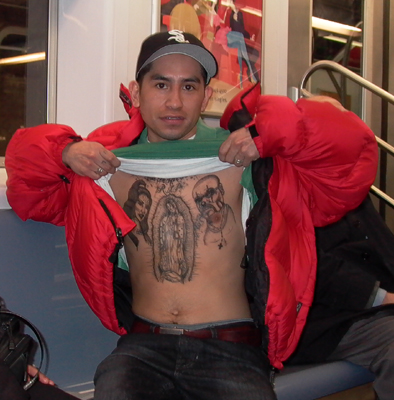 On the subway, he showed his friend his tattoos. I asked if I could take a picture. That's the Virgin of Guadalupe in the middle. I don't know the other two.